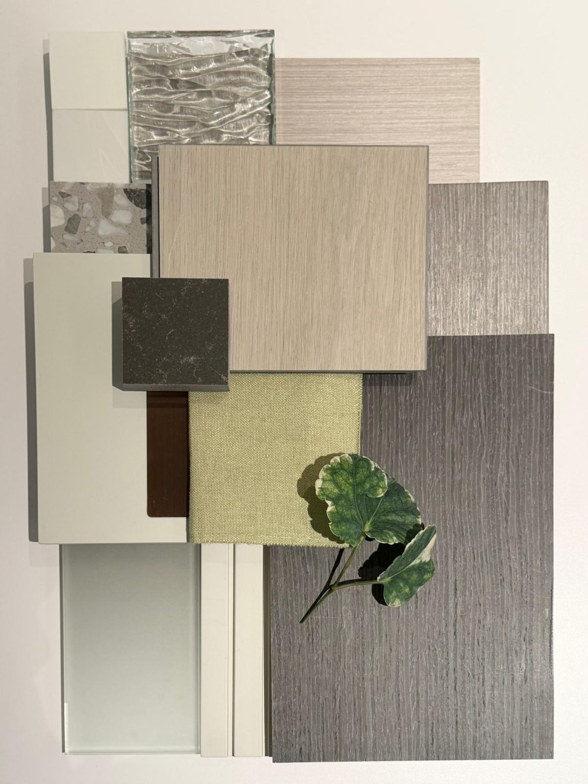 Artwill material moodboard: walnut veneer, cold-grey stone, fabric, glass, and a fresh plant leaf