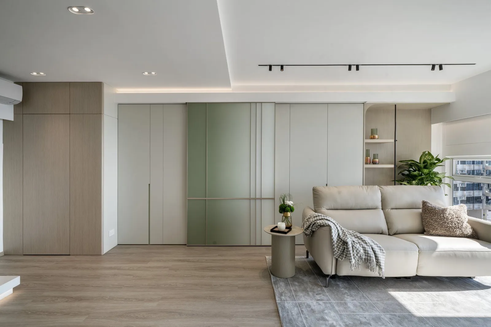 Sage-green and cream open living room in a New Territories duplex designed by Artwill